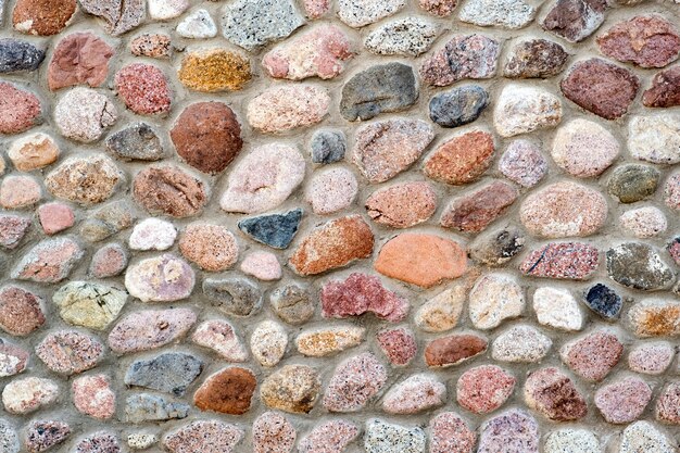 Vista de detalle plano de una pared hecha de diferentes piedras. Resumen de fondo de piedra.