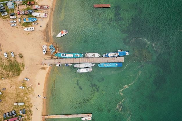 Vista diretamente acima de barcos e iates no cais em uma ilha desabitada de areia no Lago Baikal, na Sibéria.