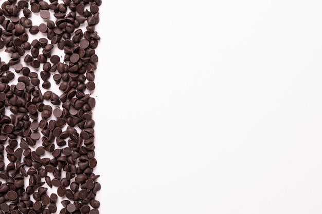 Vista diretamente acima de lascas de chocolate frescas em fundo branco com espaço de cópia