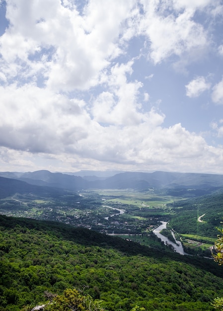 Vista do alto da montanha até o vale com o rio. Paisagem de verão.