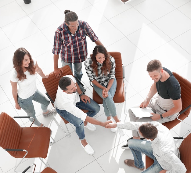 Vista do aperto de mão topa com colegas atrás de uma Deskphoto com espaço de cópia