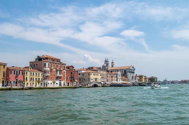 Vista do aterro do Canal de Veneza em um dia quente de verão, com barcos flutuantes e casas antigas, Veneza