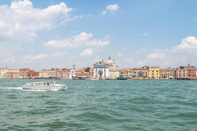 Vista do aterro do Canal de Veneza em um dia quente de verão, com barcos flutuantes e casas antigas, Veneza