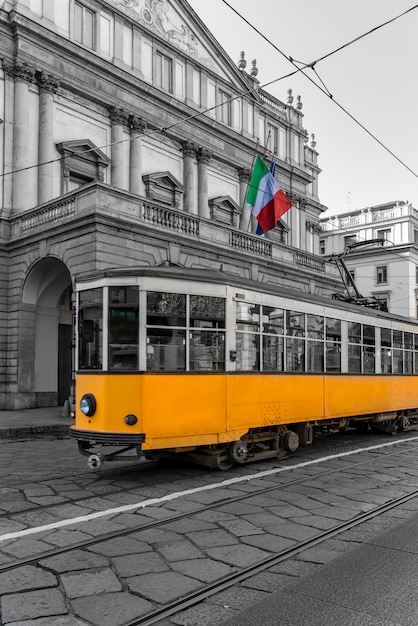 Vista do bonde amarelo passando em frente ao teatro em milão, itália