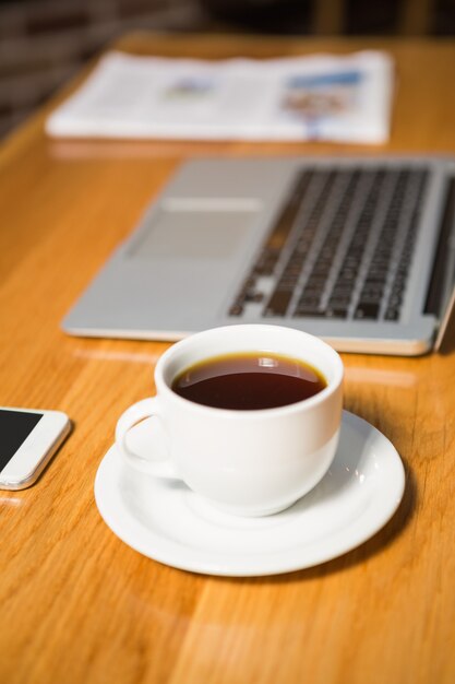 Vista do café, laptop, smartphone e jornal