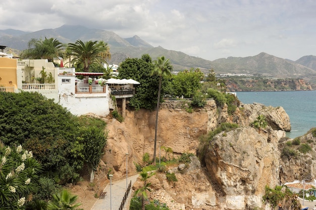 Vista do calçadão em Nerja do Balcon de Europa com nuvens de tempestade sobre as montanhas