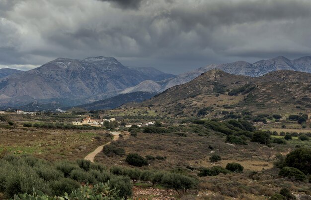 Vista do campo da aldeia do vale e montanhas à distância em uma noite nublada ilha Grécia Creta