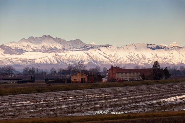 Vista do campo italiano com montanhas alpinas ao fundo