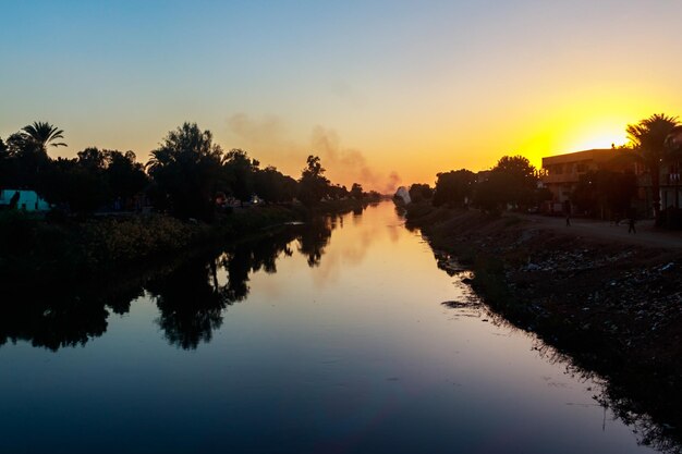 Vista do canal de irrigação ao pôr do sol no egito