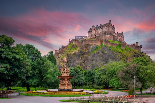 Vista do castelo de edimburgo do princes street gardens com a fonte ross em primeiro plano