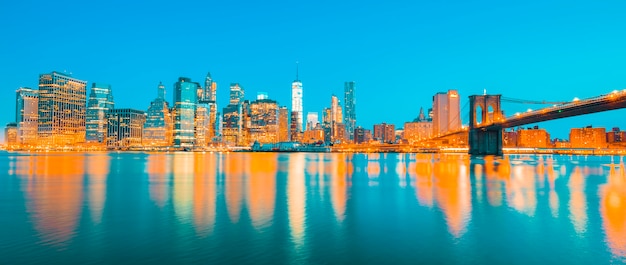 Vista do centro de manhattan em nova york ao anoitecer com arranha-céus iluminados sobre o east river