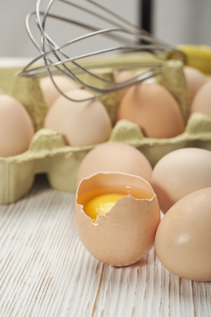 Vista do close-up de ovos de galinha crus em caixa de ovos com fundo de madeira. Ovos de galinha crus em alimentos orgânicos de caixa de ovo para uma boa saúde rica em proteínas.