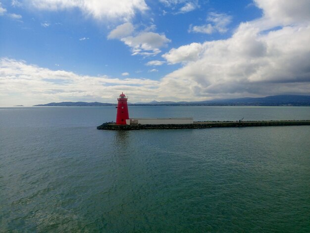 Vista do farol vermelho poolbeg no mar.