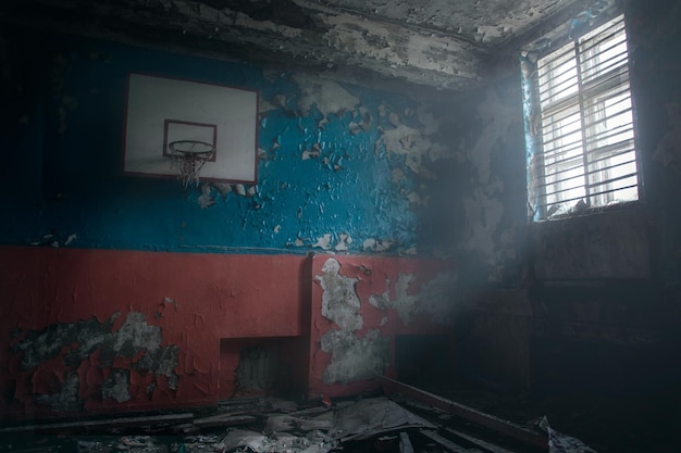 Vista do ginásio em ruínas com uma cesta de basquete na escola Teriberka. Como depois da guerra. Apocalipse.