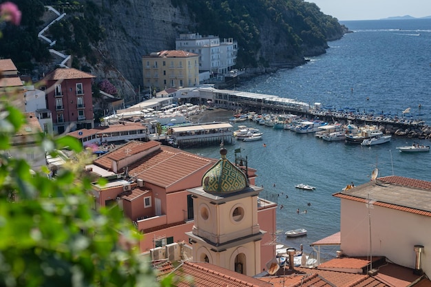 Vista do mar através dos antigos telhados e da cúpula em mosaico da igreja