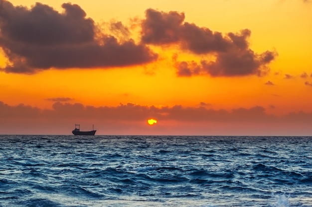 Vista do mar com navio de carga em vez por do sol