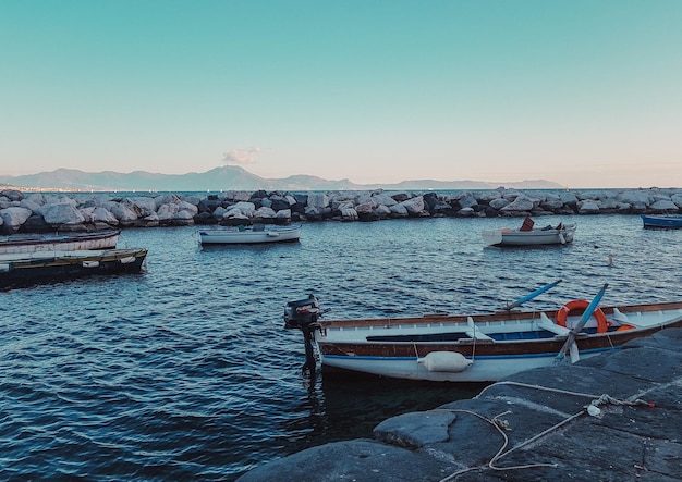 Vista do mar em Nápoles com barcos e montanhas ao fundo