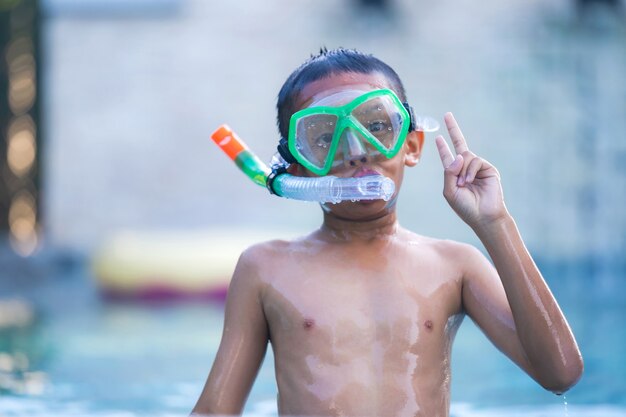 Vista do menino com óculos de natação na piscina.