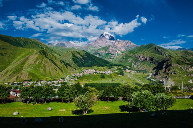 Vista do Monte Kazbek da cidade de Stepantsminda, na Geórgia, com tempo bom para escalada. É um estratovulcão adormecido e uma das principais montanhas do Cáucaso.