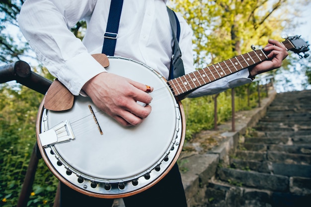 Vista do músico tocando banjo na rua