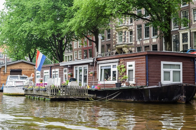 Vista do nível da água de um dos canais de uma casa de barco clássica em Amsterdã, Holanda