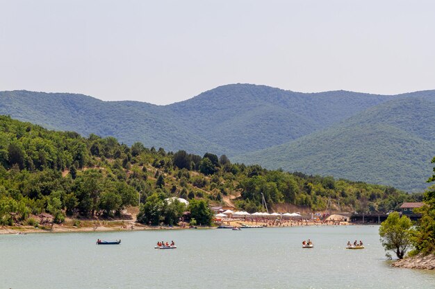 vista do parque com árvores e água, o remanso do lago com pessoas em férias