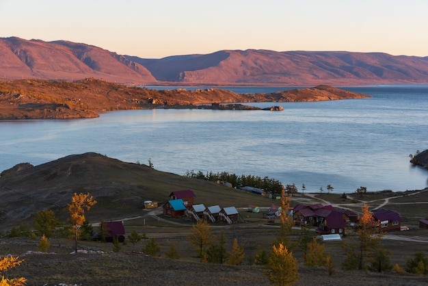 Vista do pequeno estreito do mar no lago baikal, na baía da alegria de dia de outono com casas