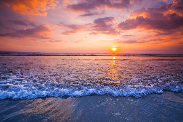 Foto vista do pôr do sol no mar com ondas de surf chegando
