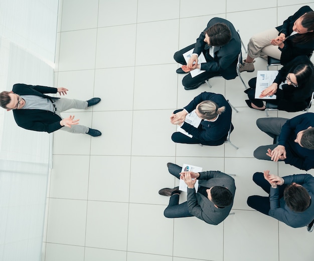 Vista do topo. Gerente falando sobre sucesso financeiro em uma reunião de trabalho.