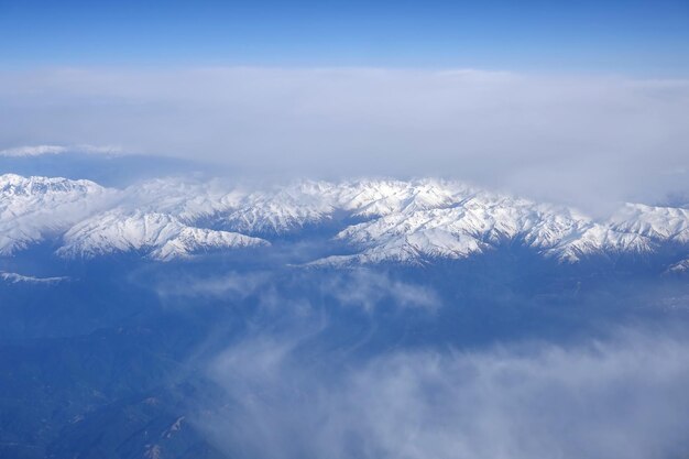 Vista dos altos picos nevados da Cordilheira Principal do Cáucaso a partir da janela de um avião voador