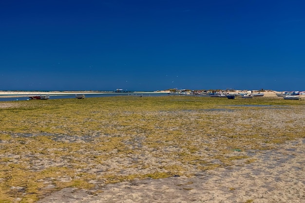 Vista dos barcos na baía na maré baixa na praia do mar mediterrâneo na ilha de djerba tunísia