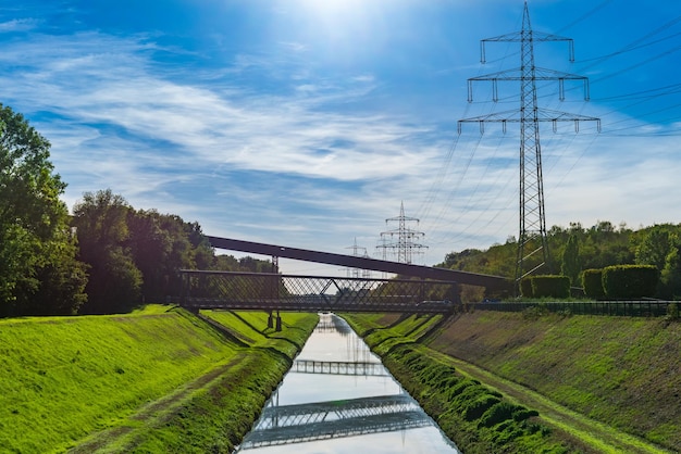 Foto vista dos postes de alta tensão do canal e da ponte de aço sobre o canal no nordsternpark em gelsenkirchen