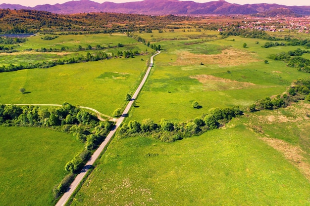Vista de drones del campo Prados de carreteras y el pueblo en las estribaciones de los Cárpatos