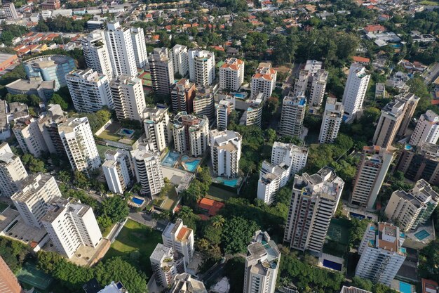 Foto vista de drones de casas contemporáneas de varios pisos en la ciudad con árboles verdes y céspedes durante el día foto