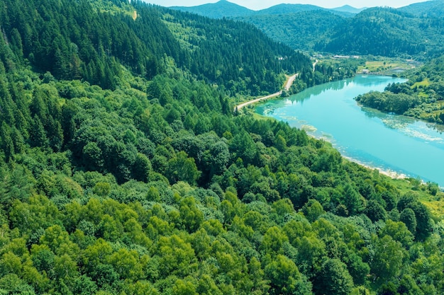 Vista de drones de un río de montaña con una presa Las montañas están cubiertas de bosque Paisaje de montaña en verano