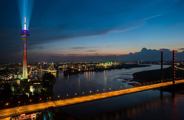 vista de Düsseldorf por la noche con la torre del Rin iluminada (Rheinturm) y espectáculo láser. ideal para diseños de sitios web y revistas