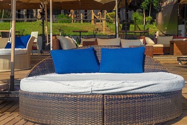 Vista de elegantes choferes VIP en forma de cama con almohadas azules en un café a orillas del mar