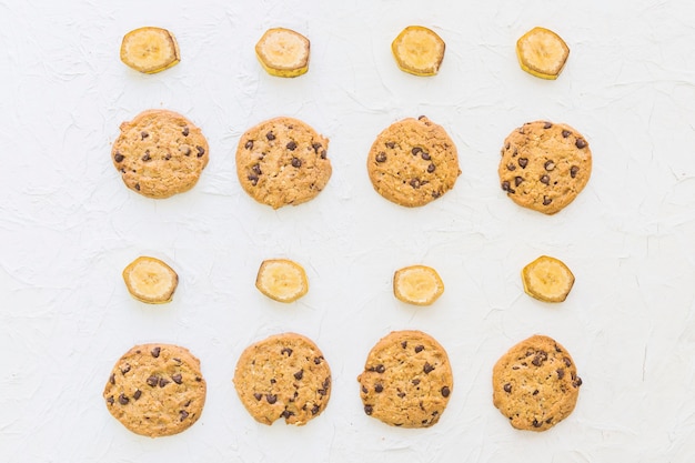 Vista elevada de galletas y rodajas de banana en una fila