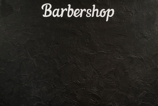 Foto vista elevada de una palabra de barbería sobre fondo negro