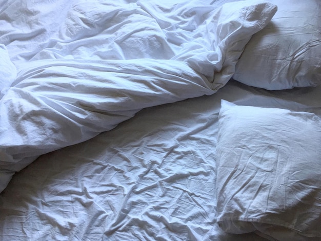 Vista elevada de una sábana blanca arrugada sobre una cama en una casa
