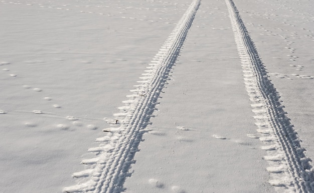 Foto vista em alto ângulo de rastros de pneus na neve