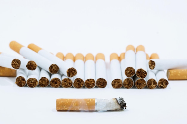 Vista em alto ângulo de um cigarro na mesa contra um fundo branco