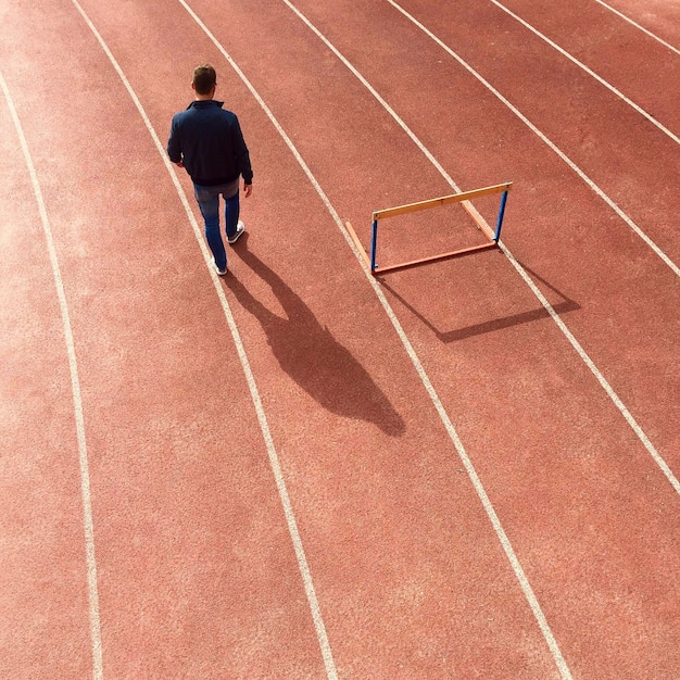 Vista em alto ângulo de um homem caminhando em trilhas de corrida