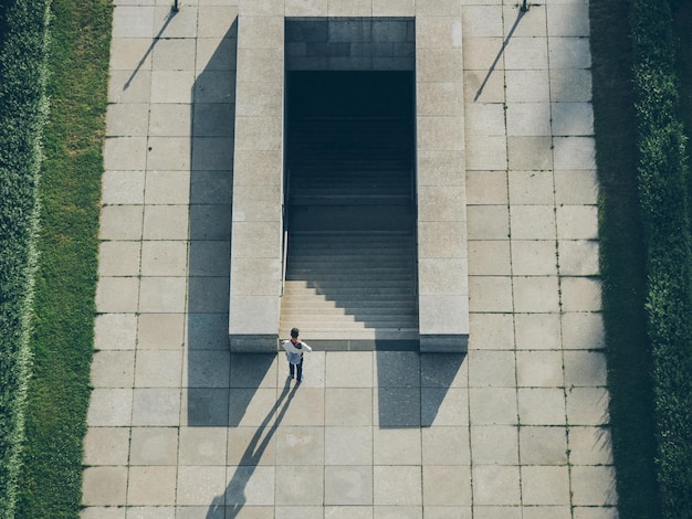 Vista em alto ângulo de um homem de pé junto a escadas