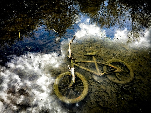 Foto vista em alto ângulo de uma bicicleta abandonada no lago