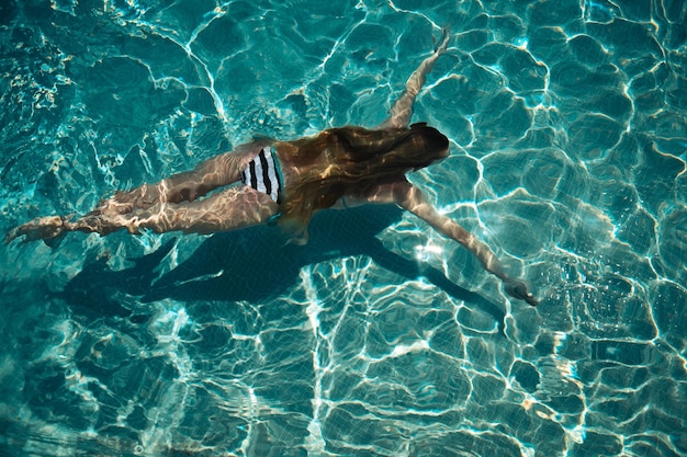 Foto vista em alto ângulo de uma pessoa a nadar na piscina