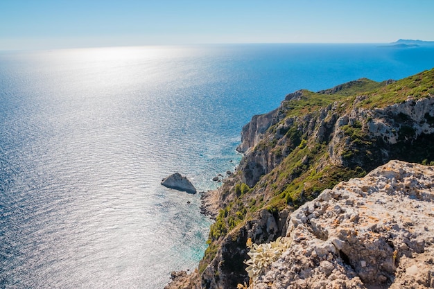 Vista em incríveis barcos de baía com pessoas nadando na água azul do Mar Jônico perto de Cavernas Azuis