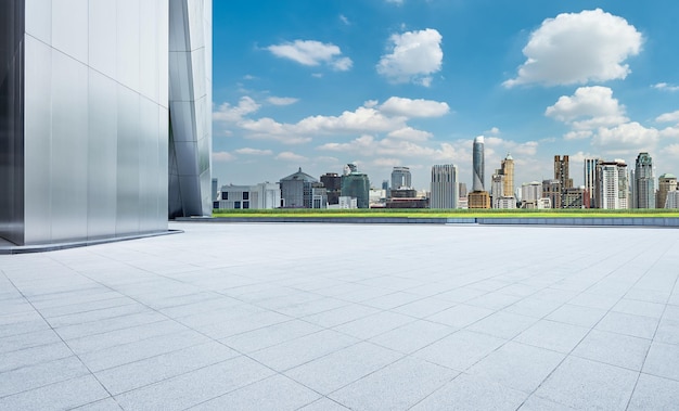 Vista em perspectiva do piso de ladrilhos de concreto vazio com horizonte da cidade