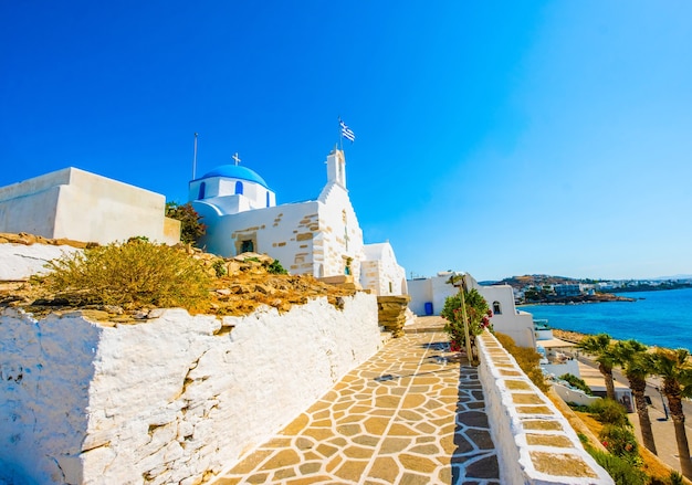 Vista emocionante da igreja grega em frente à costa turquesa do mar