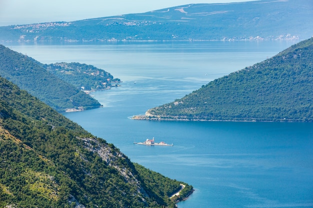 Vista enevoada do verão da Baía de Kotor e da cidade de Kotor na costa (Montenegro)